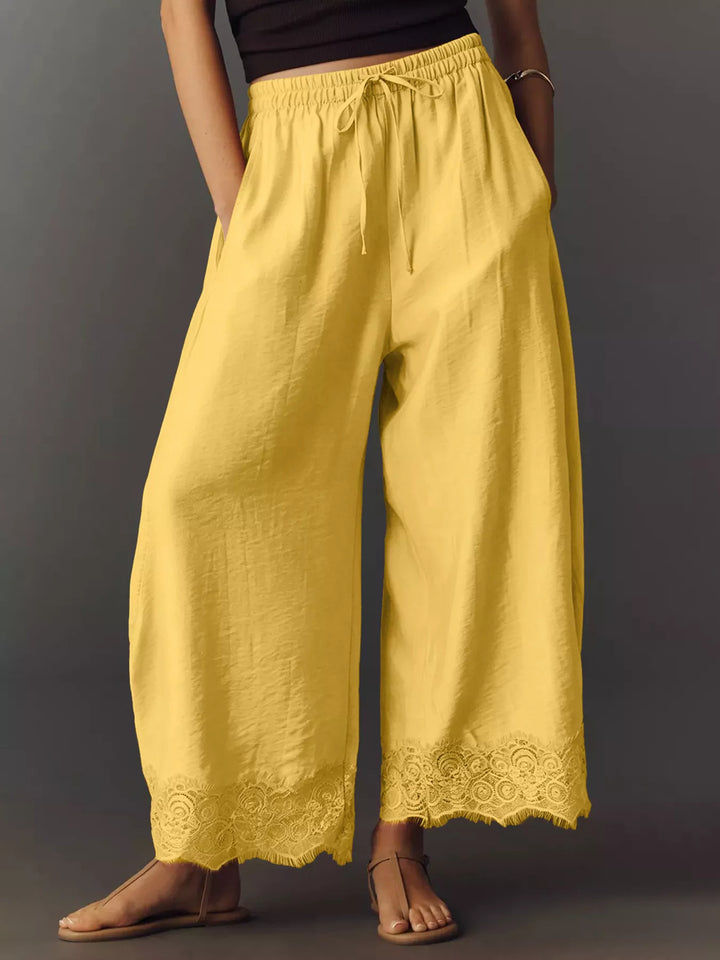 Yellow wide leg pants front view with drawstring waist and lace trim