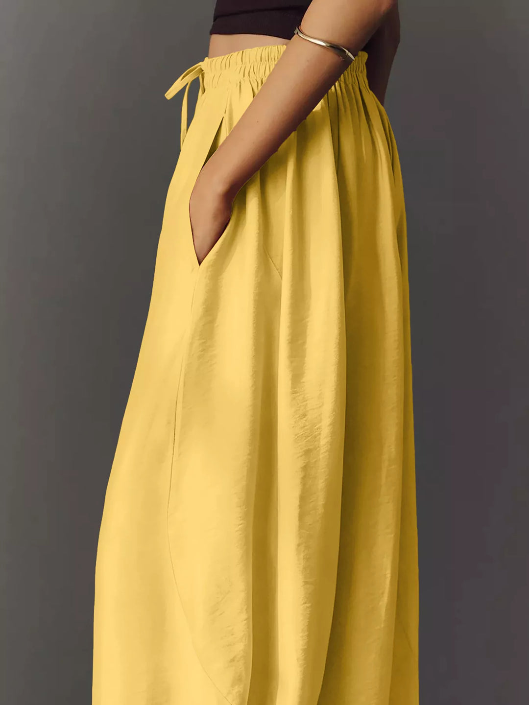 Side profile of the yellow pants with a hand resting in the pocket
