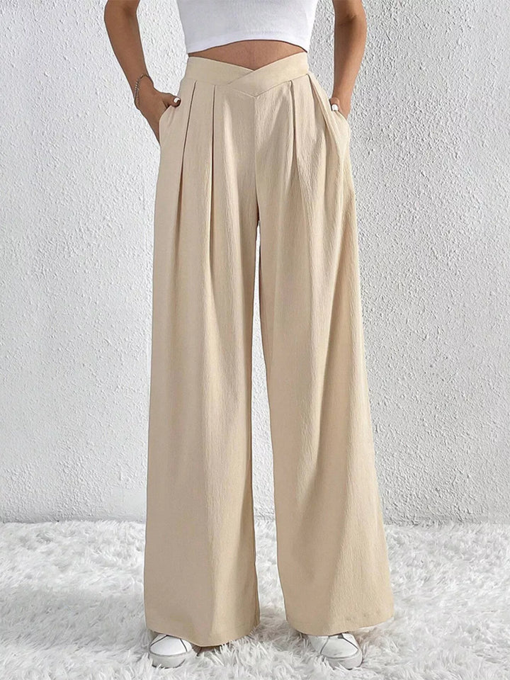 Beige high waist wide leg pants with side pockets, hand in pocket