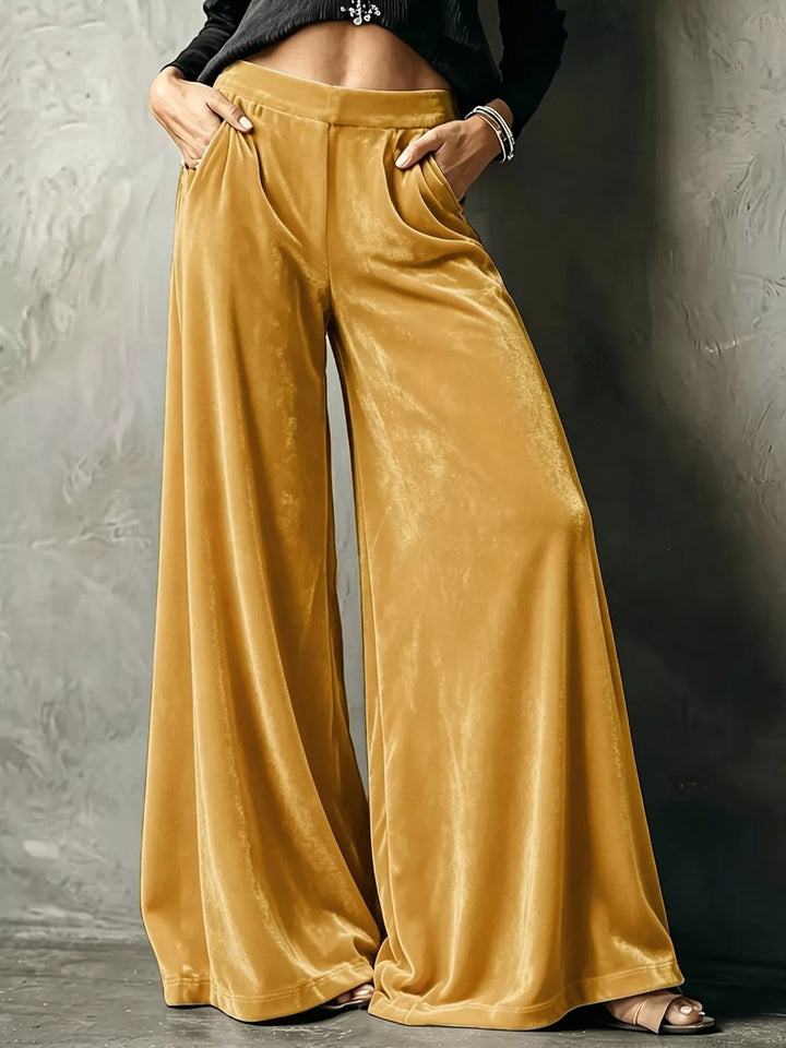 Mustard yellow high waisted wide leg pants with a shiny velvet-look finish