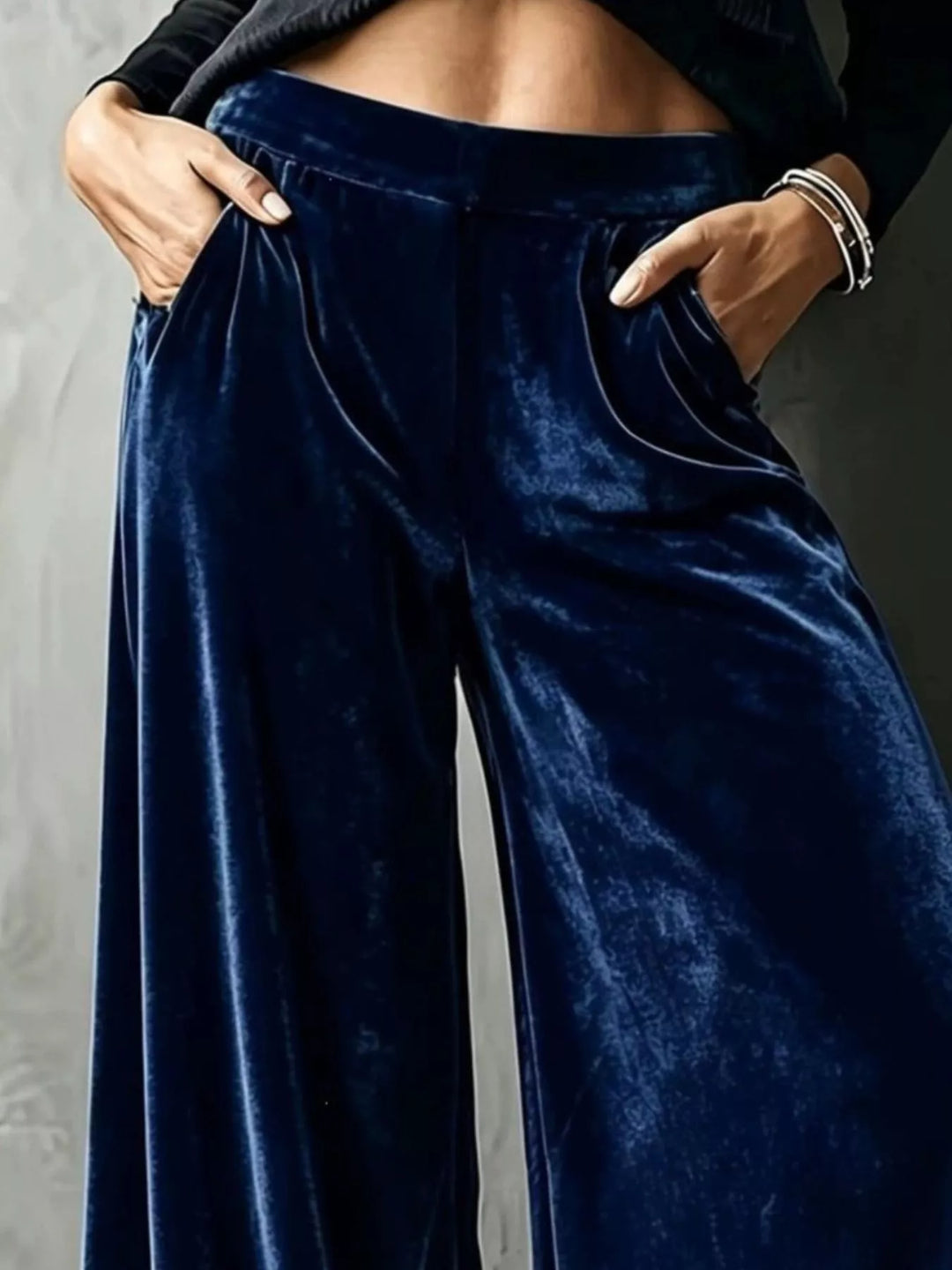 Close-up of navy wide leg pants showing pockets and the shiny drape