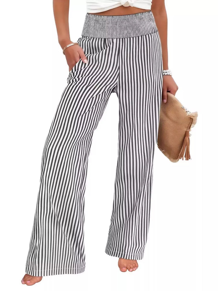 Black striped high waisted wide leg pants with a clutch, front view on white