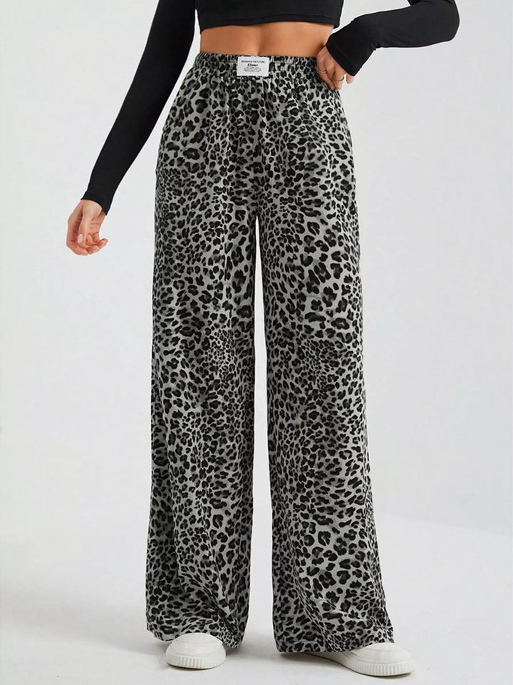 Gray leopard wide leg pants, front view with one hand at the hip