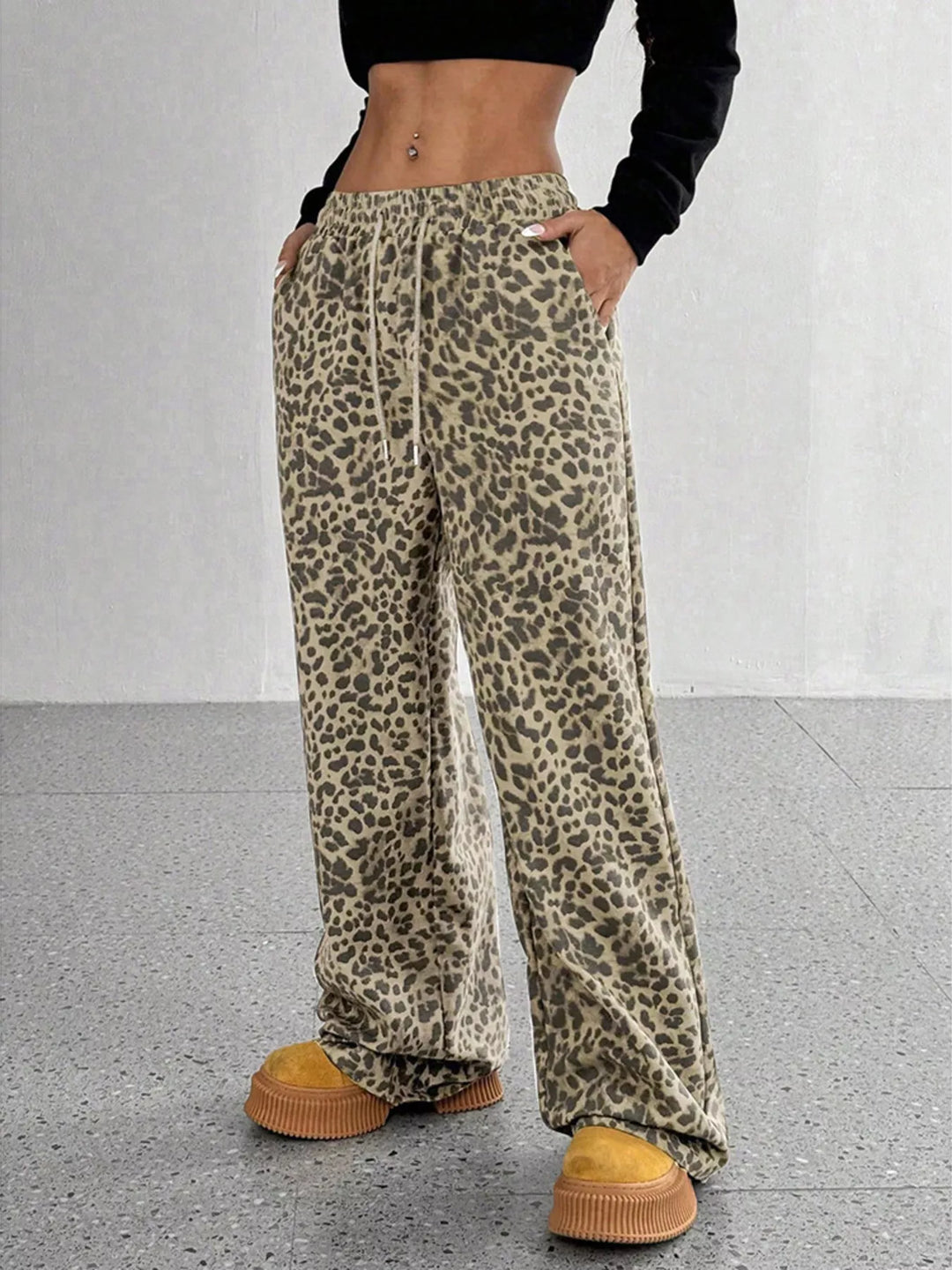 Khaki leopard print wide leg pants styled with a black crop top and yellow shoes