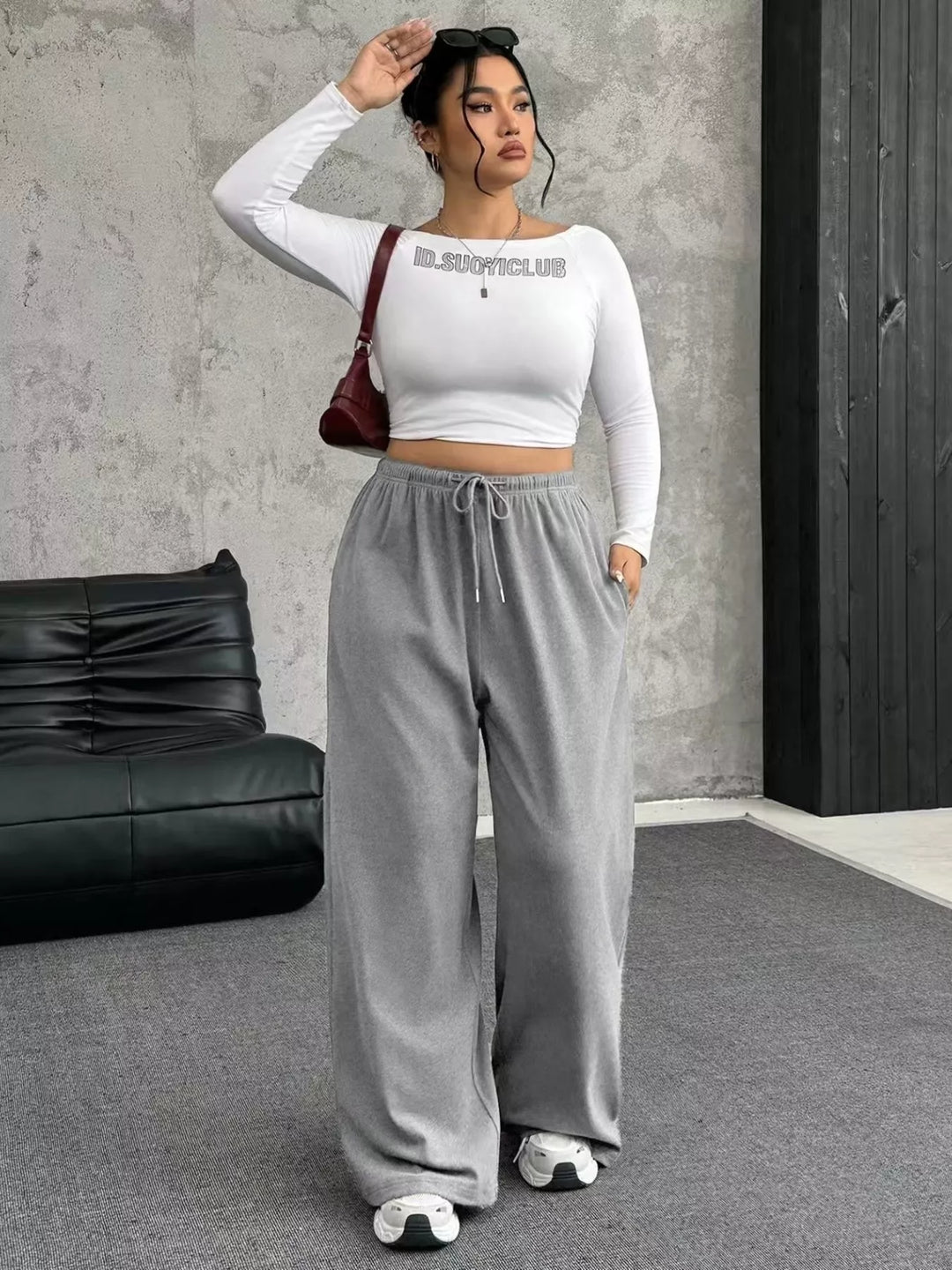 Light gray wide leg pants styled with a white crop top and red bag