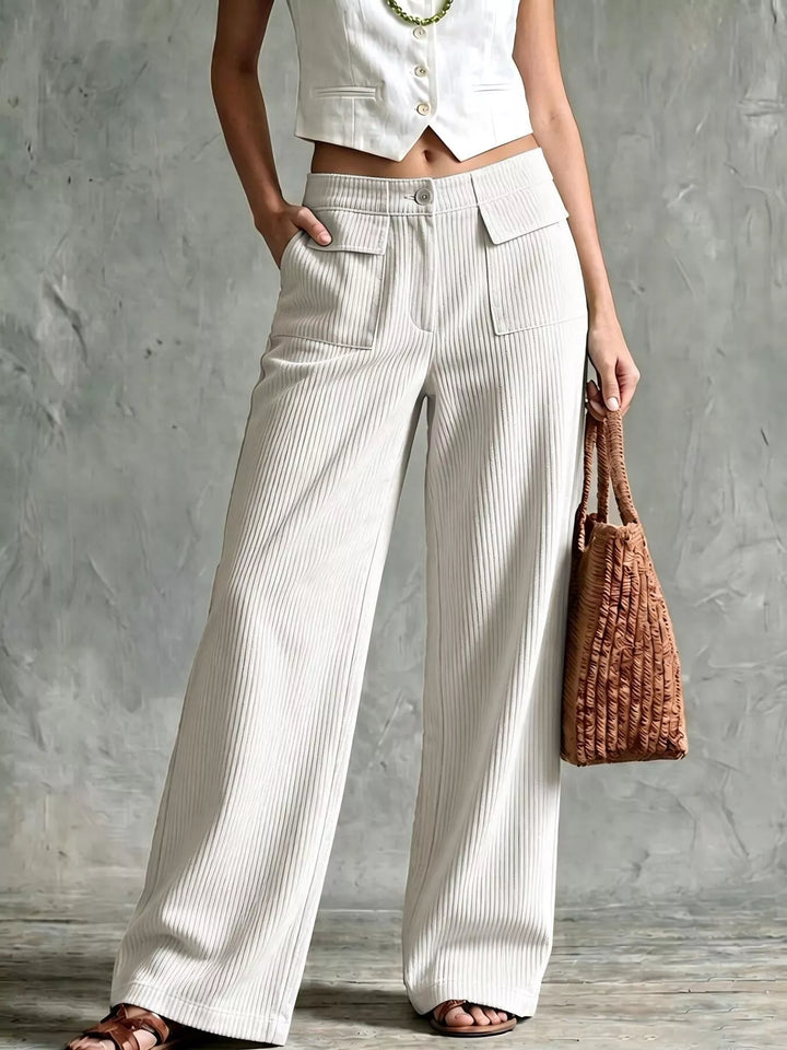 Women's white wide leg pants with ribbed texture, front view with woven bag