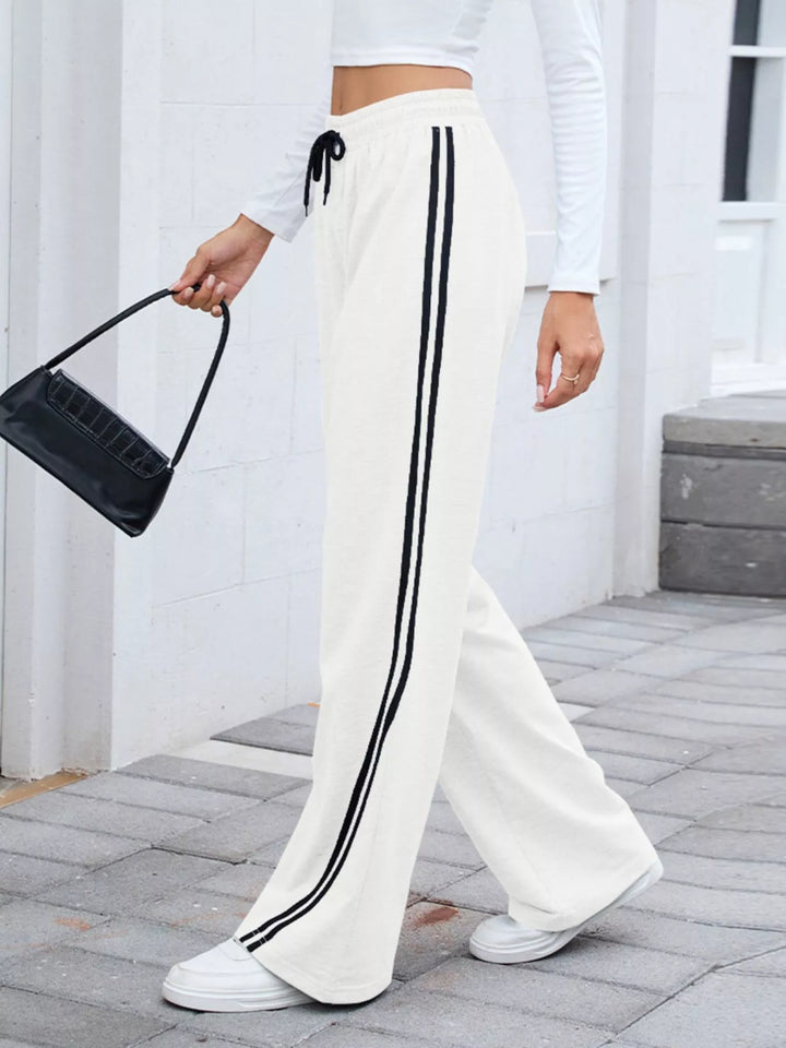 White side striped wide leg pants styled with a black shoulder bag