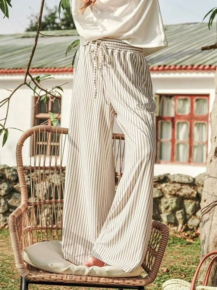 Women's wide leg pants in beige thin stripe, high waisted and flowy, outdoors