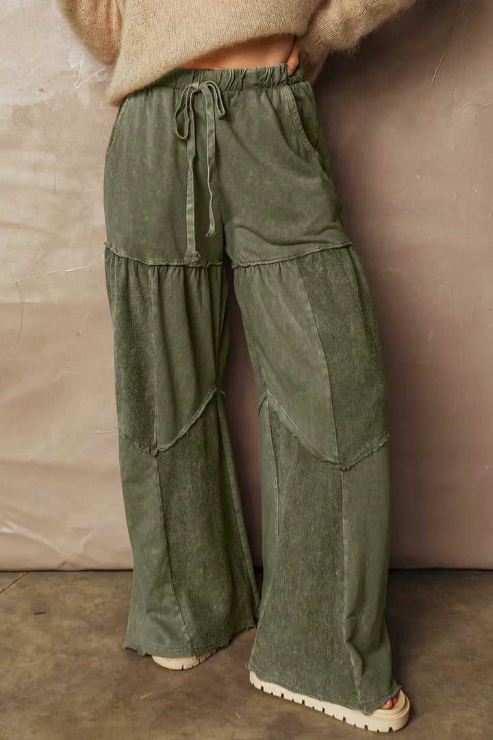 Olive green washed look wide leg pants with a drawstring, styled with a knit top