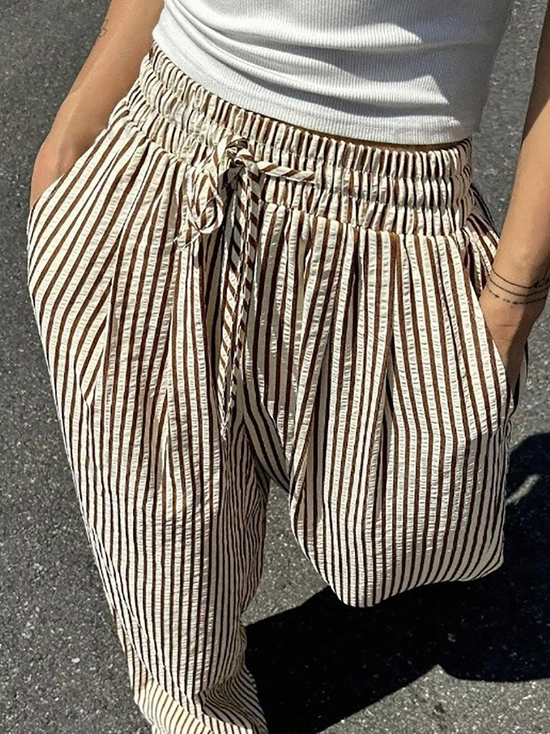 Close-up of the brown striped pants gathered waist and drawstring bow