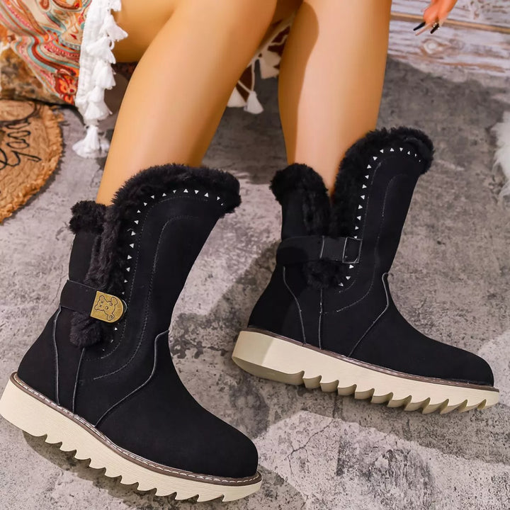 Pair of black mid calf boots with fur cuffs and a chunky treaded sole