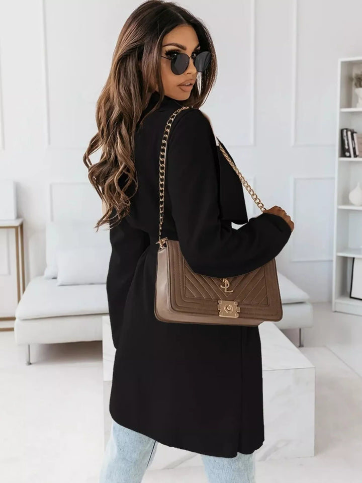 Black belted coat seen from behind with a brown chain bag