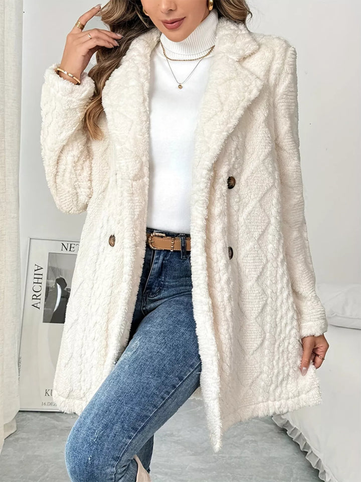 Front view of the ivory double breasted coat worn open over a white turtleneck and jeans
