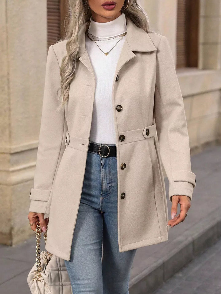 Women's beige winter coat, fitted button up with collared lapel, worn over a white turtleneck