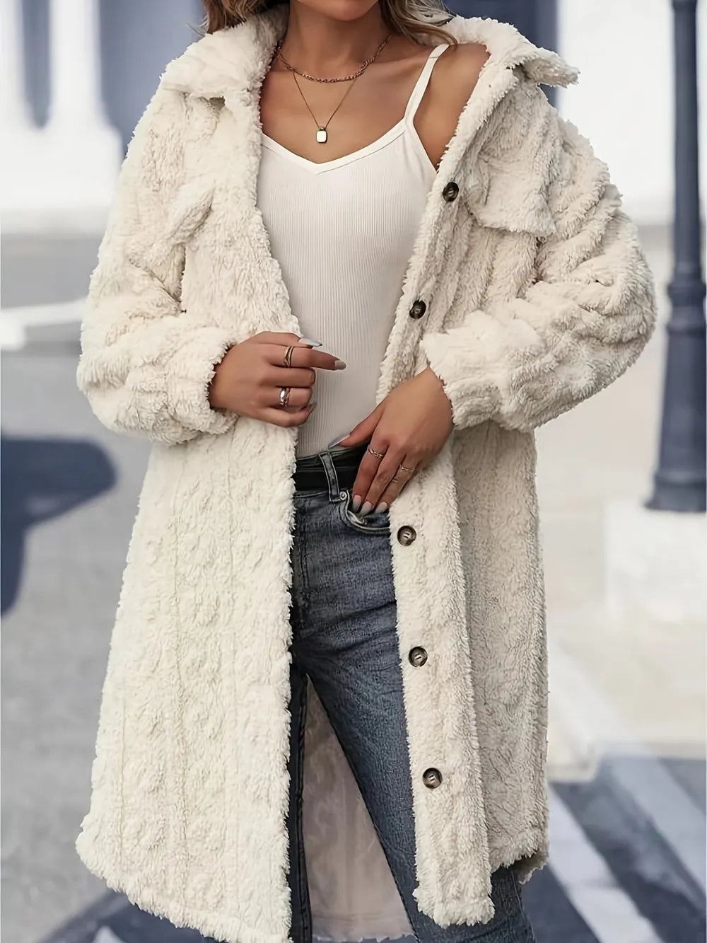 Front view of the cream fuzzy coat with collar, chest pockets and long buttoned placket