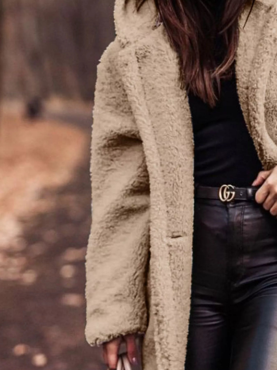 Close-up of the beige plush hooded coat with hand on the lapel