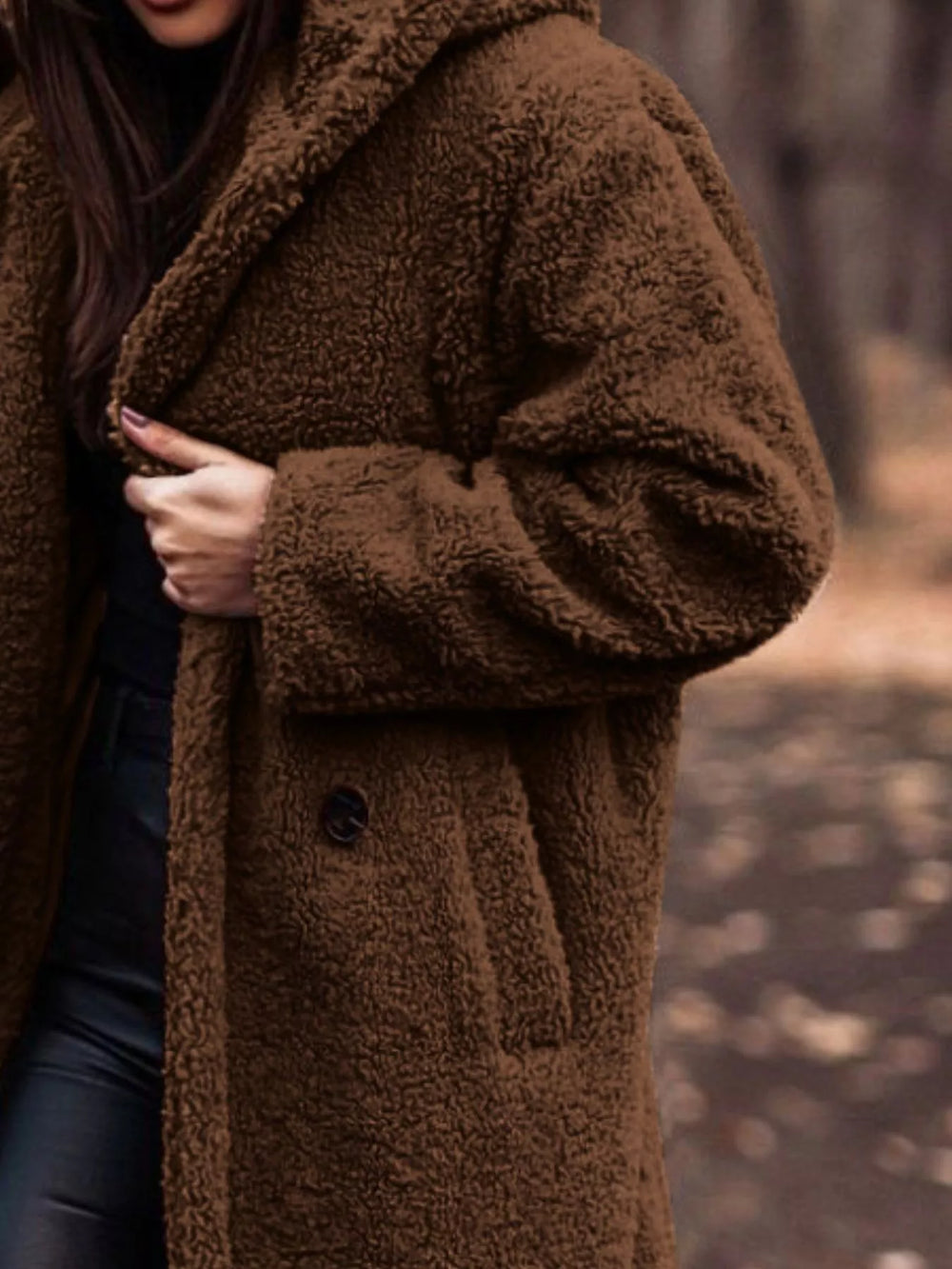 Close-up of the chocolate plush hooded coat with hand on the lapel