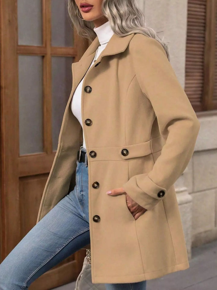 Side view of the camel coat with hand in pocket in front of a window