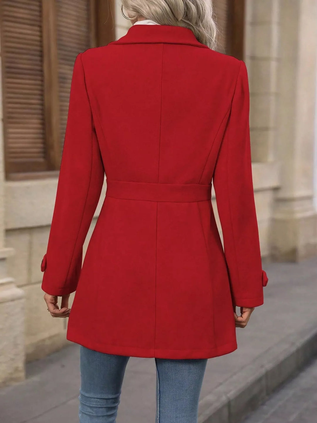Back view of the red coat with fitted belted waist